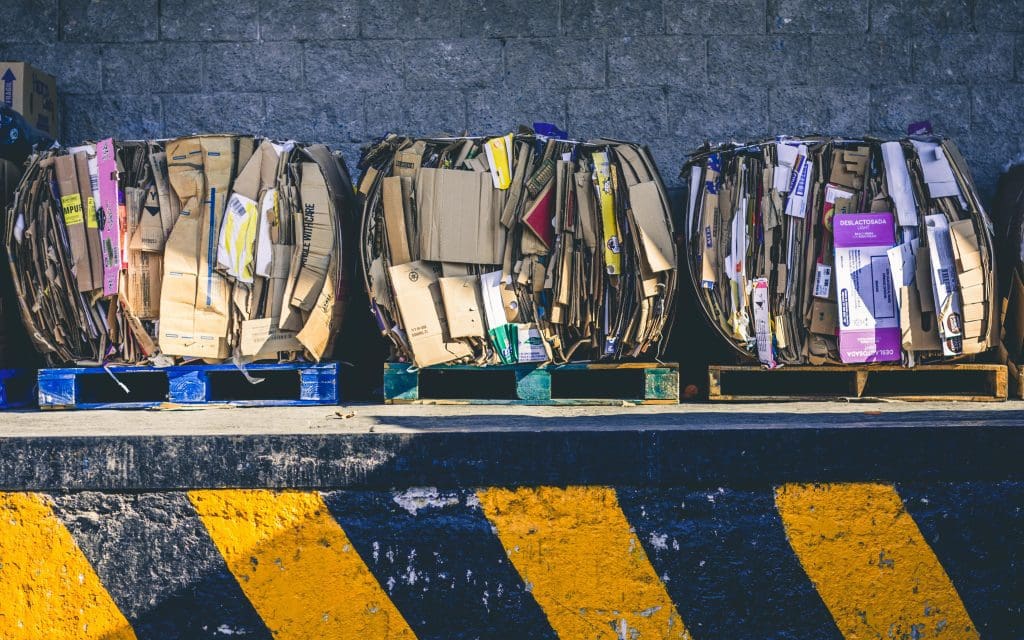 Three blocks of cardboard than have been crushed and tied by a recyling baler