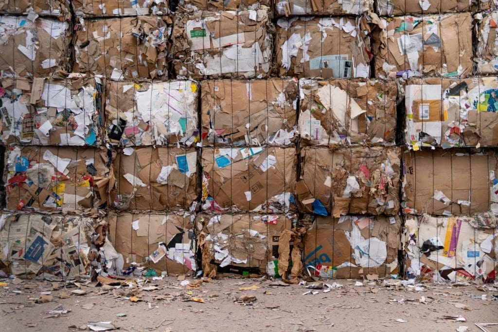 Facts about Canada's recycling efforts. An overhead shot of a large amount of recyclable plastic waste, including crushed bottles, yoghurt pots and containers.